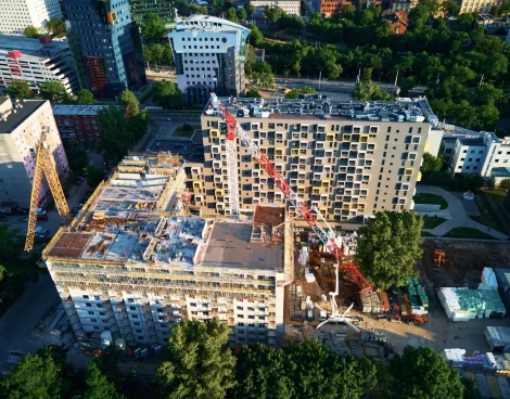 Aerial view of construction site with residential building under construction. Tower crane on construction site in city